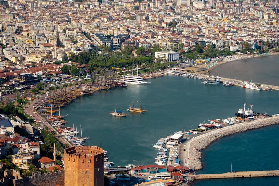 Kaleiçi harbor in Antalya: historic tower, yachts and wooden gulets along Mediterranean coastal town waterfront.