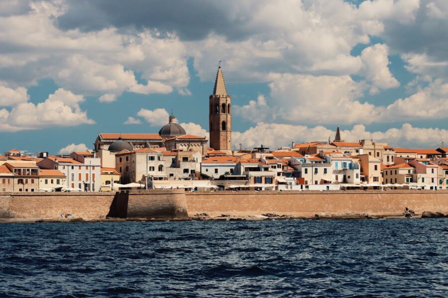 Picturesque coastal town with charming architecture, bell tower, boats, and serene waters.