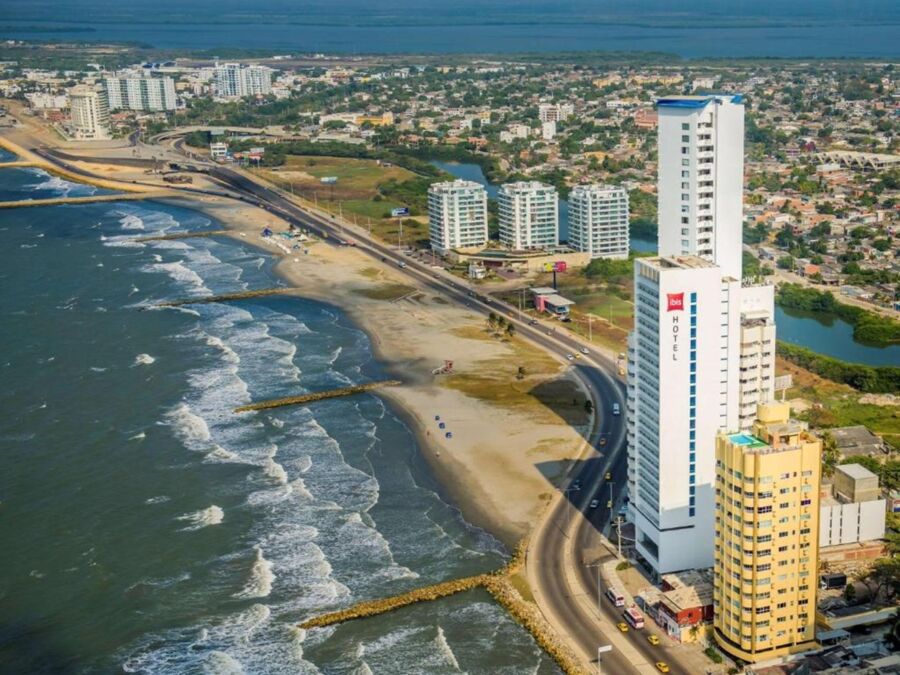 Vibrant coastal town with modern buildings, sandy beach, and serene ocean views.
