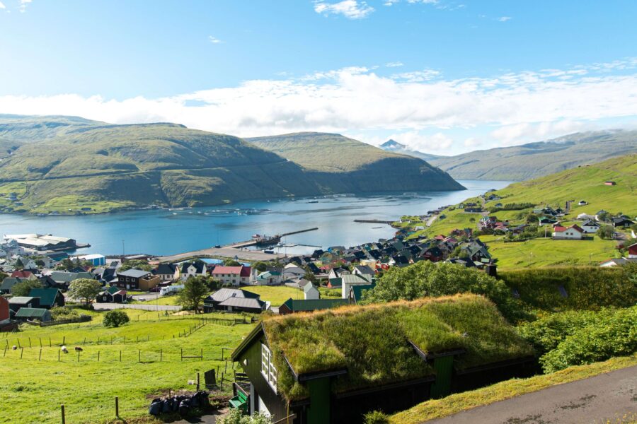 Vestmanna, Faroe Islands: coastal village with turf-roof houses, harbor piers, and calm fjord.