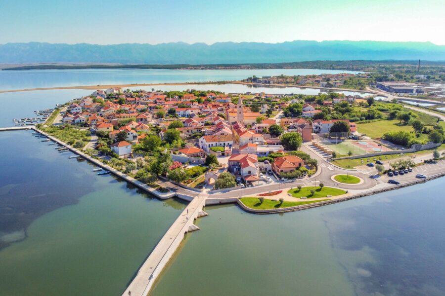 Aerial view of vibrant coastal village with colorful houses and serene water.