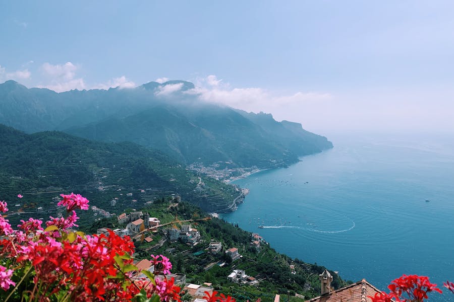 Amalfi Coast, Campania, Italy: terraced coastal village, red flowers, panoramic sea view.