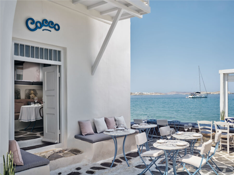 Charming seaside restaurant Coco with serene views, coastal architecture, and elegant dining setup.