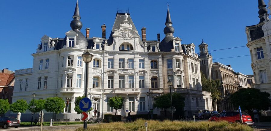 Large white building with numerous windows on Cogels-Osylei Street in Antwerp.
