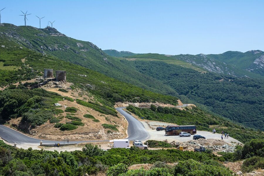 Scenic view of a winding road with wind turbines along the side, located in Col de la Serra, Corsica, France.
