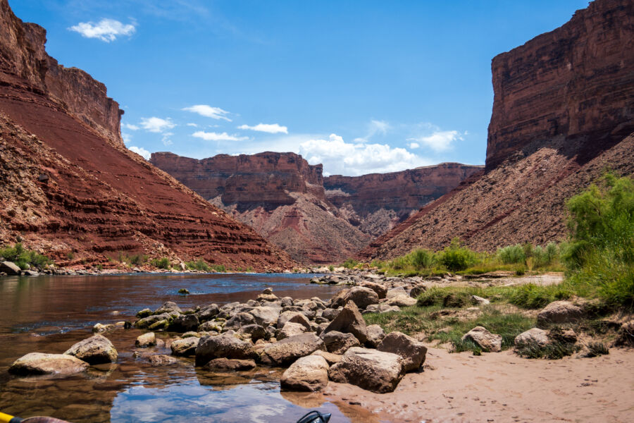 Expansive view of Grand Canyon National Park showcasing towering walls, mountains, and the Colorado River winding through valleys