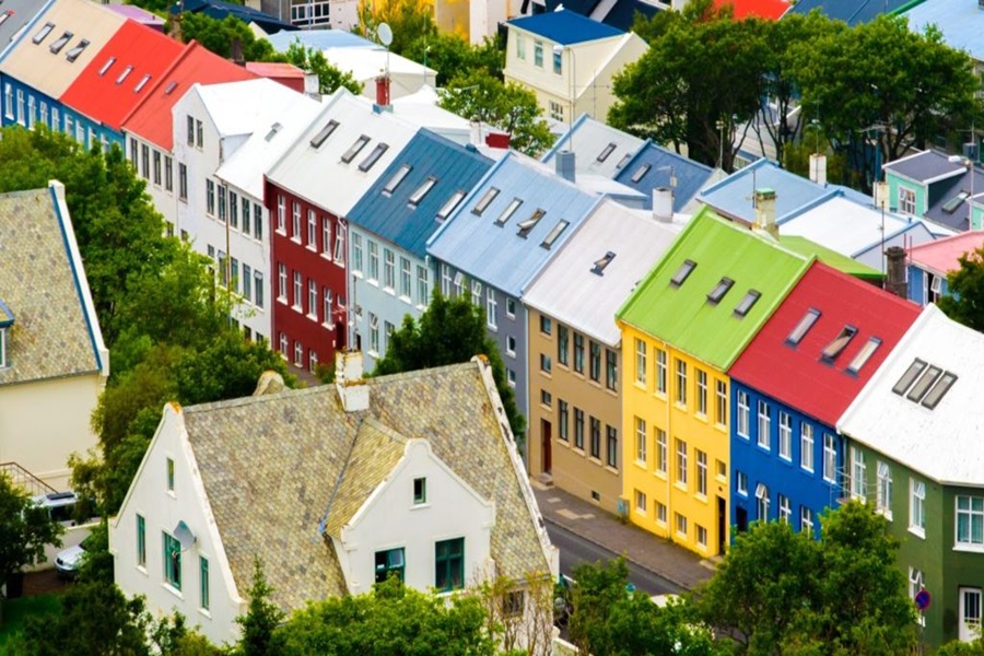 Vibrant Scandinavian houses with colorful roofs and lush greenery in a lively neighborhood.