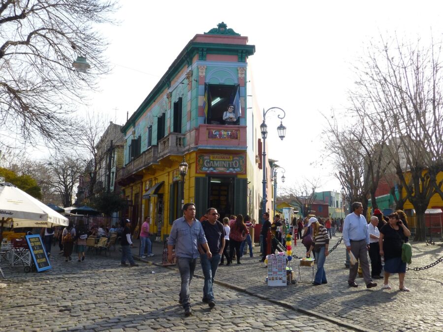 Vibrant La Boca street scene with colorful buildings, lively crowd, and historic charm in a bustling neighborhood.