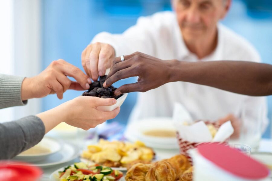Communal dining scene with diverse hands sharing snacks, emphasizing cultural unity and togetherness.