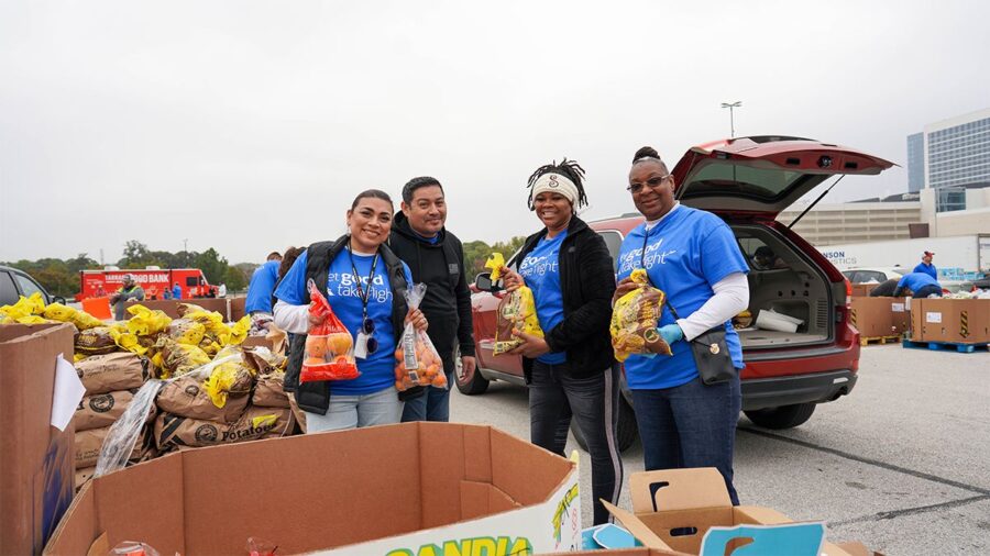 Volunteers distribute food at community event, promoting hunger relief and solidarity.