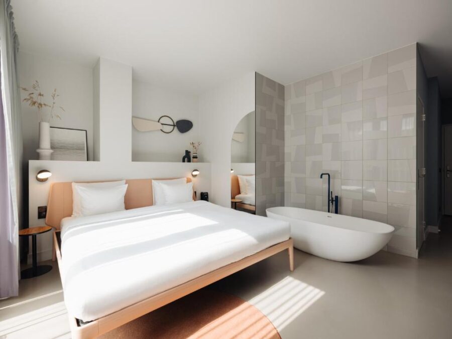 Hotel room at Conscious Hotel Museum Square, featuring a large bed and a stylish bathtub.