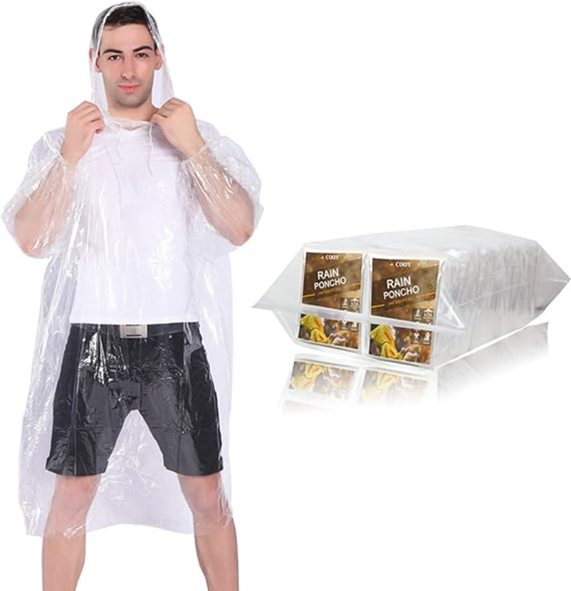 Man wearing a plastic raincoat stands with a bag, representing COOY 10-Pack Rain Ponchos for rainy days.