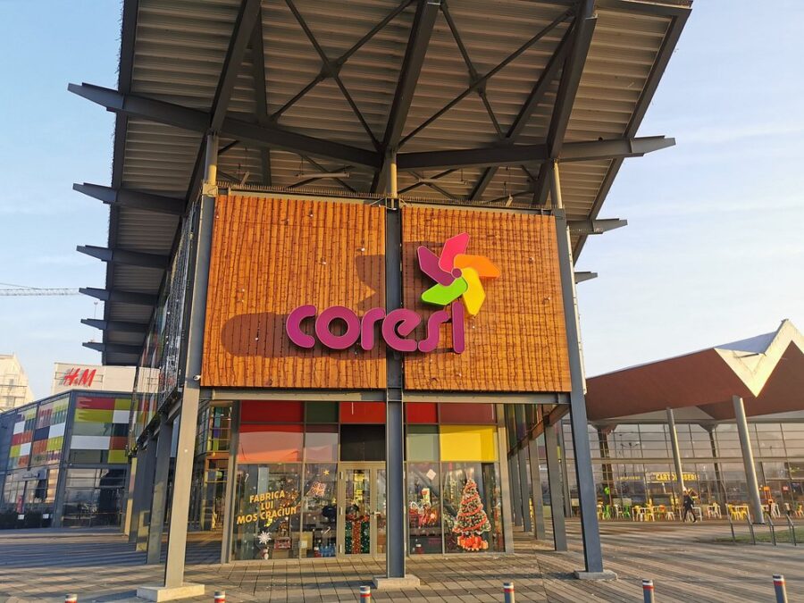Colorful storefront sign at Coresi Shopping Mall in Brasov, Romania, inviting shoppers to explore the retail space.