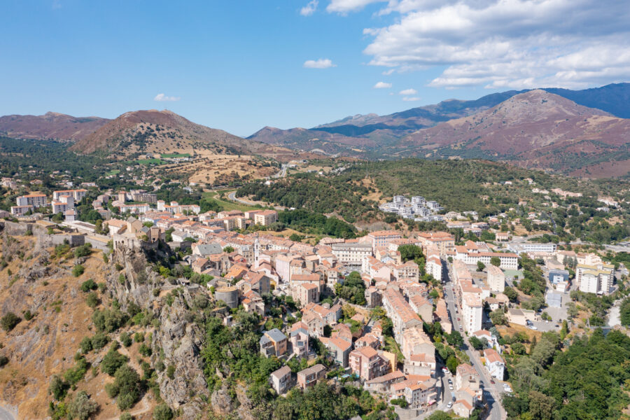 Aerial view of Corte in Corsica, France, showcasing its charming layout and surrounding landscape.