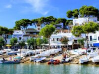 Row of boats docked in a serene harbor along the Costa Brava coastline in Spain.