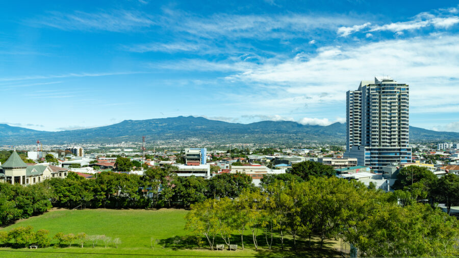 Street view of San Jose, Costa Rica, featuring city buildings with mountains in the background, San Jose Province