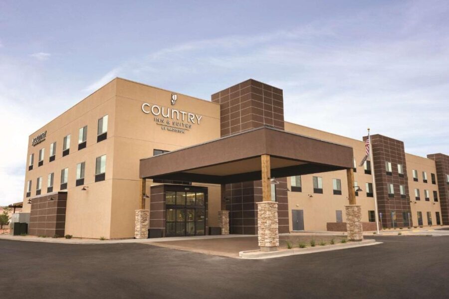 Exterior view of Country Inn & Suites by Marriott in Albuquerque, showcasing its charming architecture and signage.
