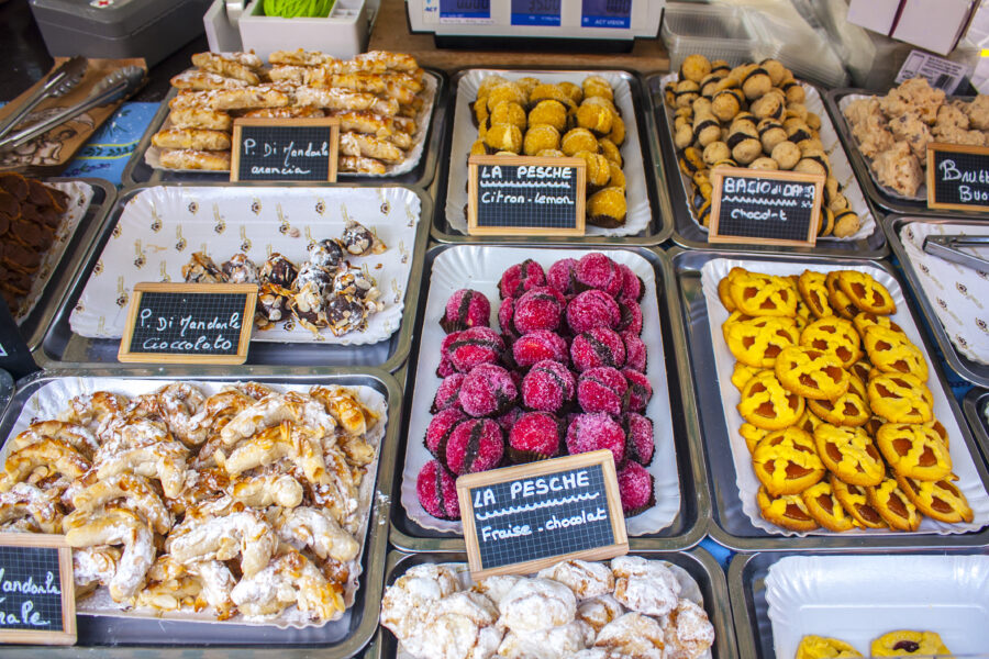 Display of colorful French pastries at Cours Saleya market in Nice, showcasing various sweet treats and desserts