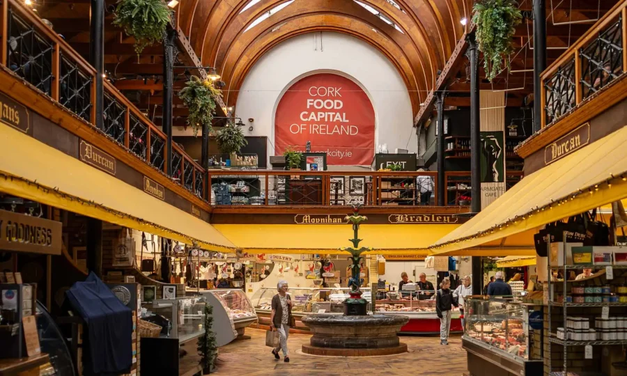 Cork covered food market hall interior with wooden vaulted ceiling and deli stalls.