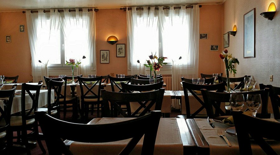 Cozy bistro dining room with wooden tables, wine glasses, and natural light.