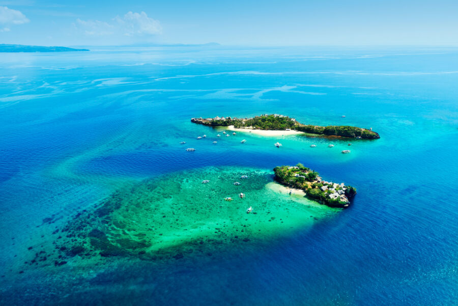 Aerial view showcasing the lush greenery and turquoise waters surrounding Magic and Crocodile Islands in the Philippines