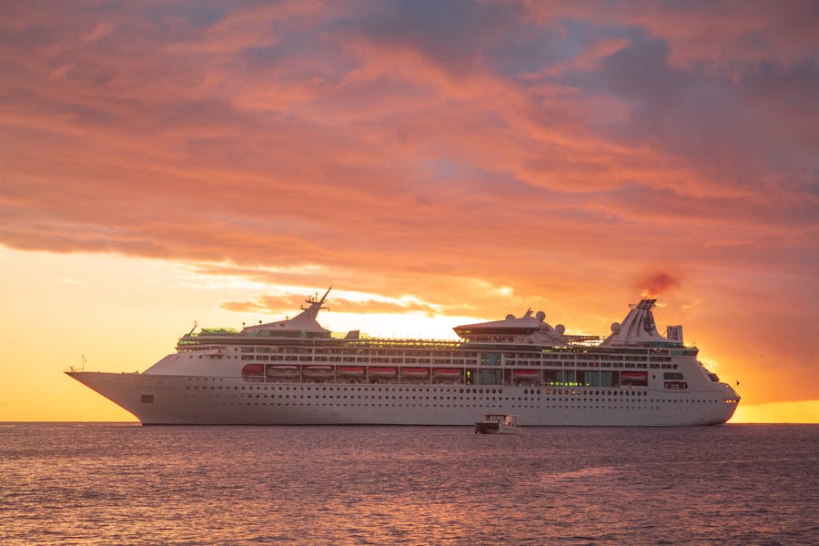Luxurious cruise ship at sunset on calm waters.
