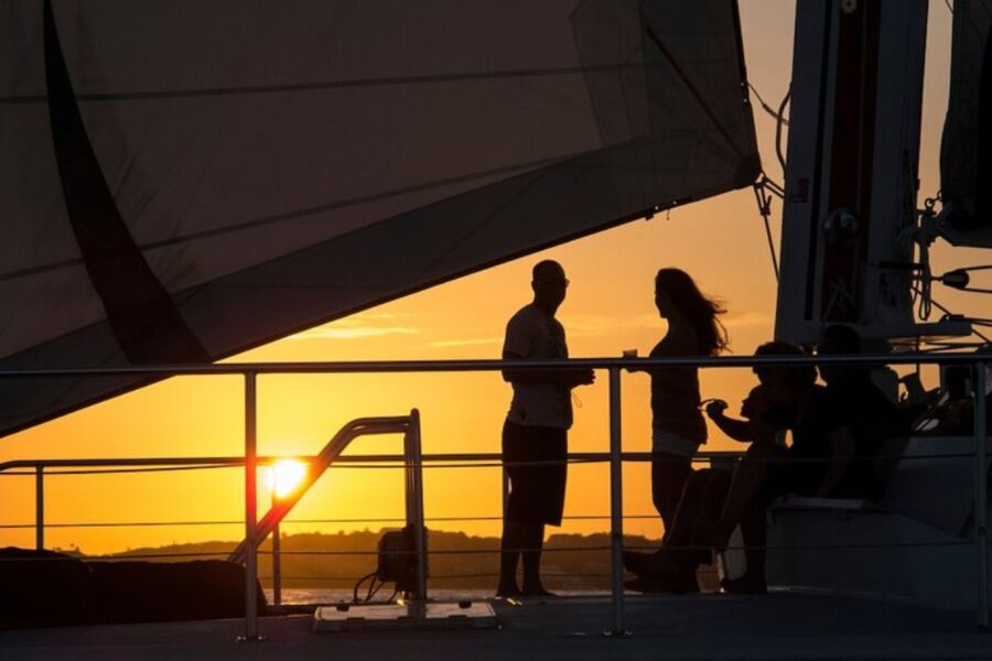 People aboard a sailboat at sunset, experiencing the beauty of Cruz Bay during a memorable sailing adventure.