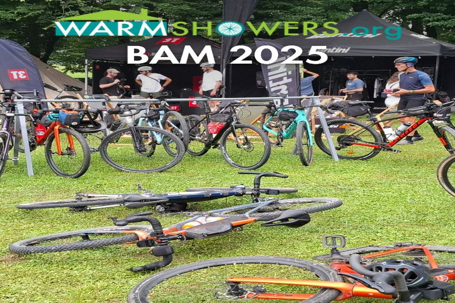 Cycling event with colorful bikes, lush setting, WarmShowers tents, and enthusiastic participants.