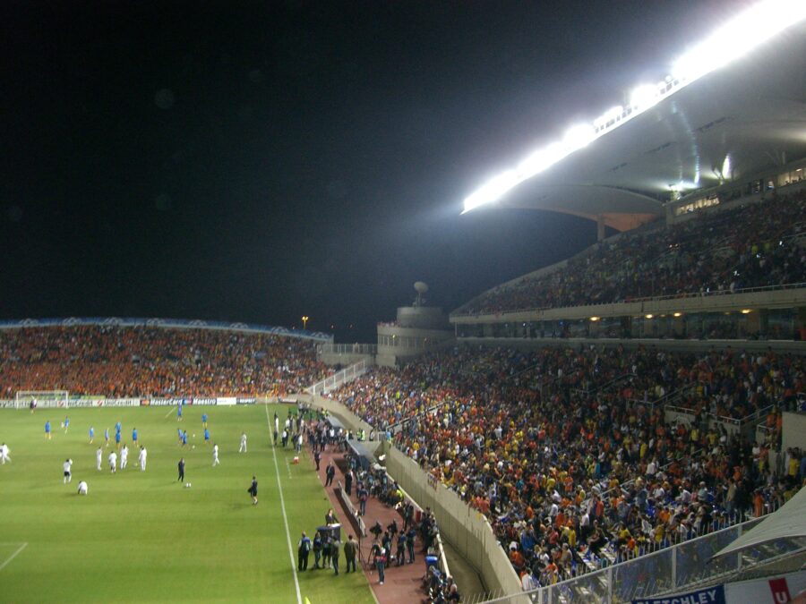 Exciting scene of a Cyprus football game in a packed stadium, showcasing players in action and enthusiastic fans.
