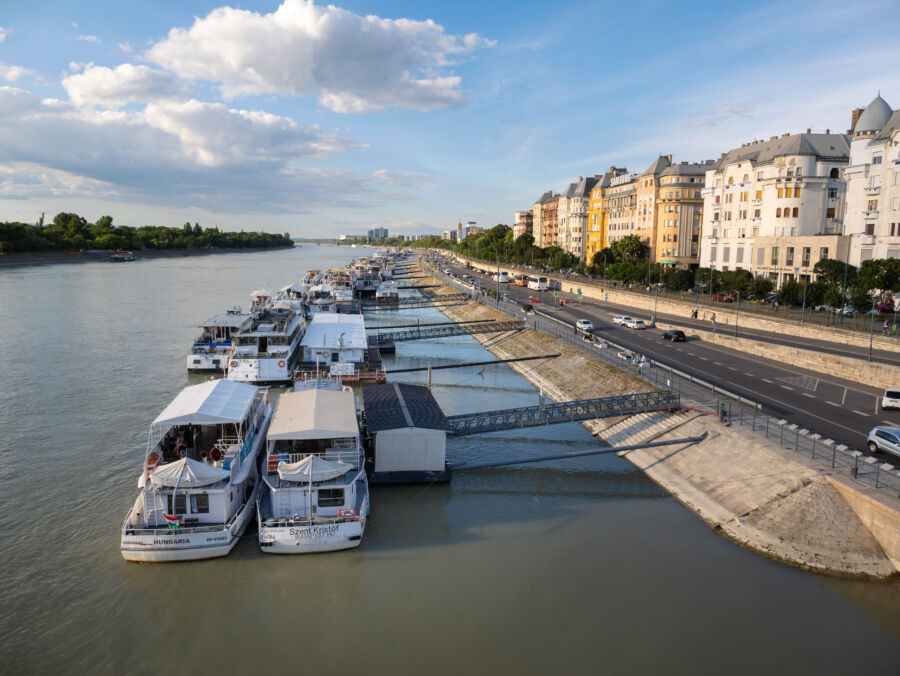 Scenic panorama of the Danube River in Budapest, showcasing boats at the docks with the city skyline