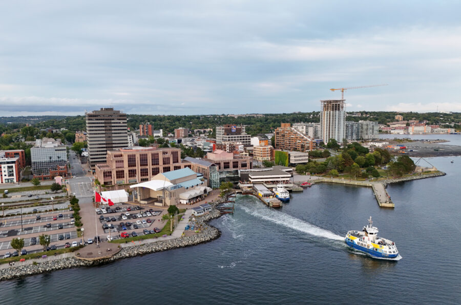 Scenic view of Dartmouth, Nova Scotia, featuring the waterfront and city skyline against a clear blue sky.