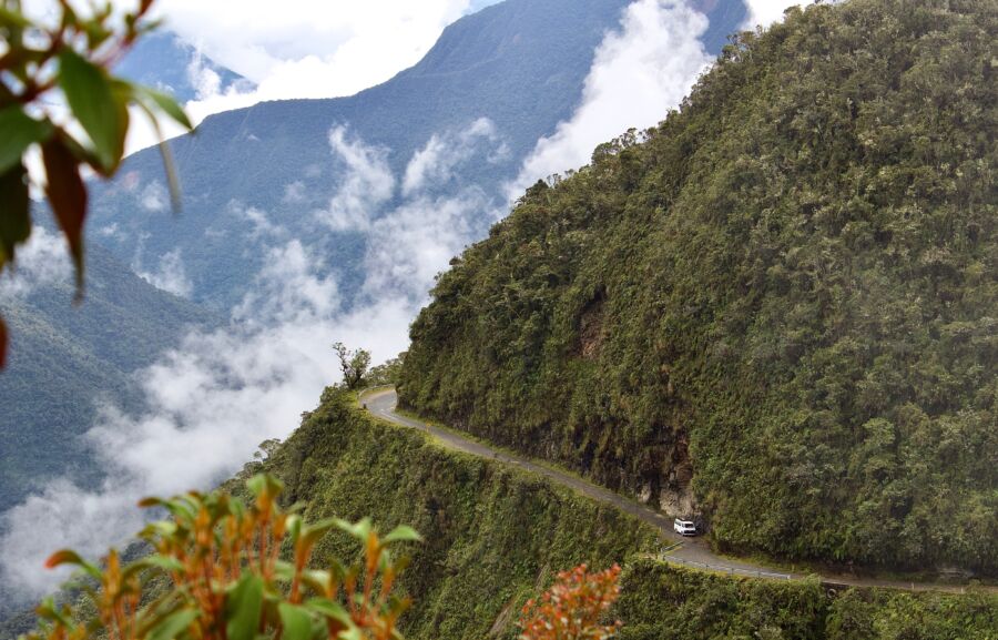 Scenic perspective of Bolivia's Death Road, featuring dramatic cliffs and narrow roads amidst vibrant natural landscapes