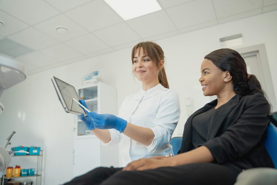 Modern dental office consultation with a dentist explaining treatment to a smiling patient.