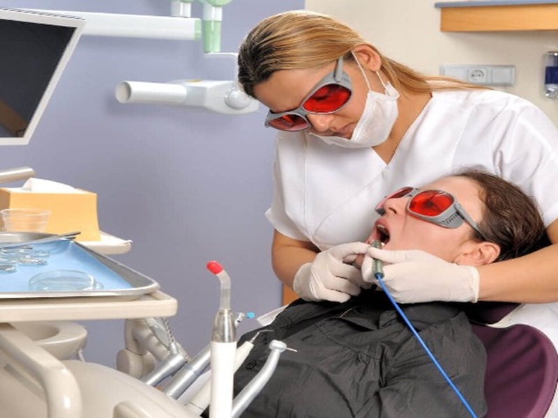 Dentist performing procedure in a modern, hygienic dental clinic.