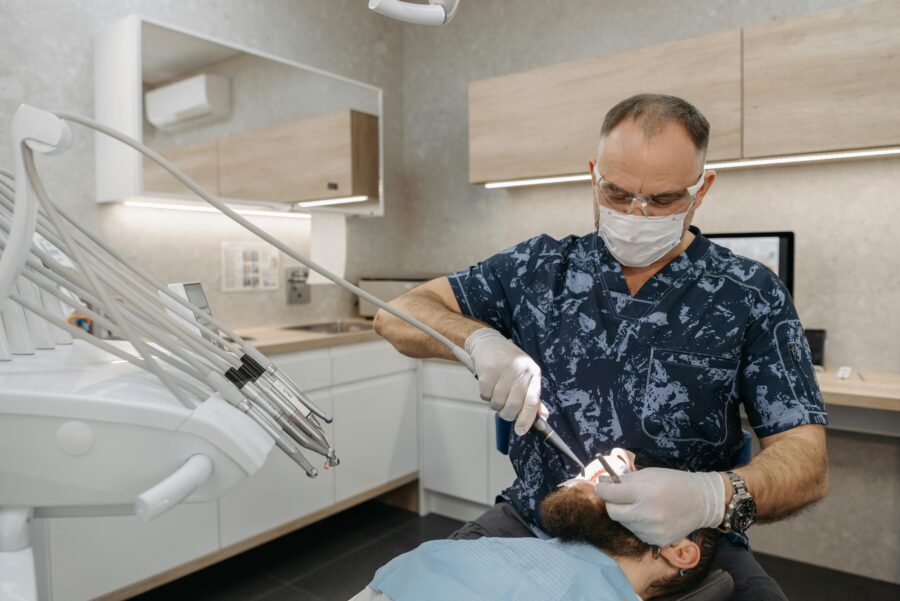 Dentist performing procedure in modern clinic with organized tools and digital technology.