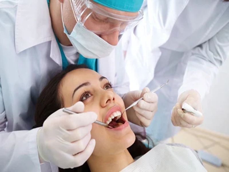 Dental examination: young woman, dental professionals, modern clinic, oral health care.