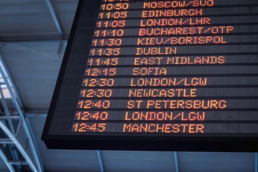 Airport digital departure board showing international flight times and destinations.