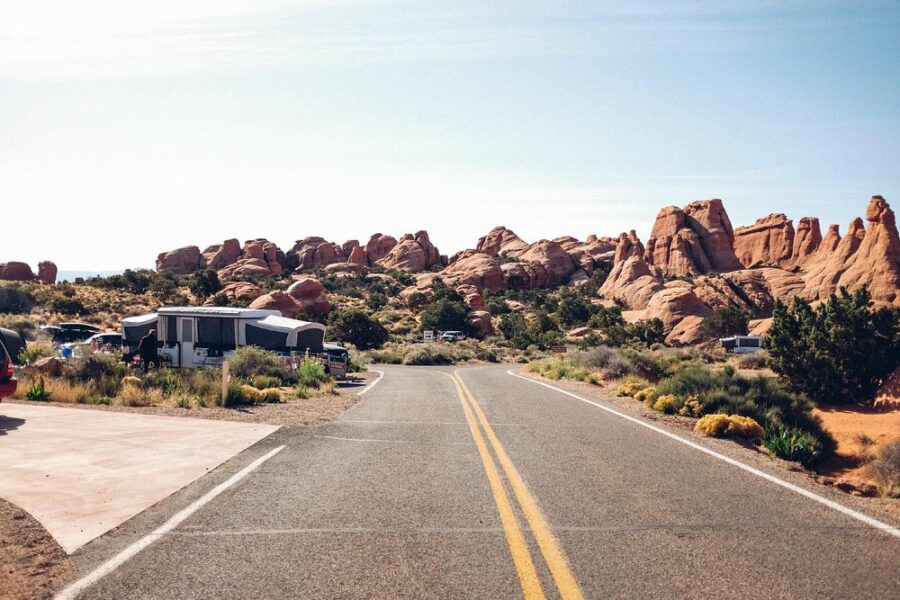 Camper van parked by the road at Devils Garden Campground, Utah, with rocky formations in the background.
