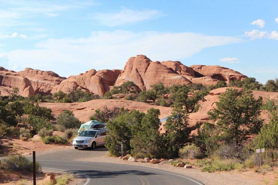 Camper van rests on the roadside near rocks at Devils Garden Campground in Utah, surrounded by natural beauty.