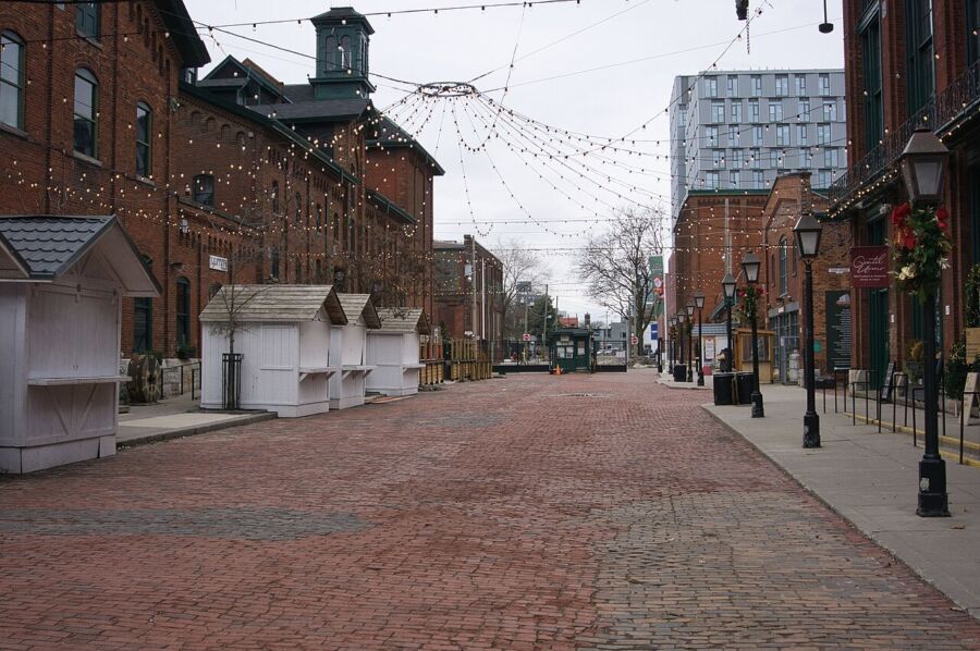 Trinity Street in Toronto's Distillery District, showcasing a clock tower and a few surrounding buildings.
