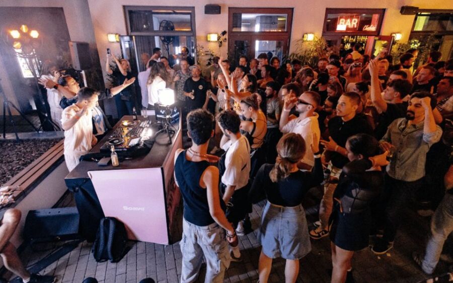 Vibrant nightlife party with DJ performance, diverse crowd, music, and energizing atmosphere.