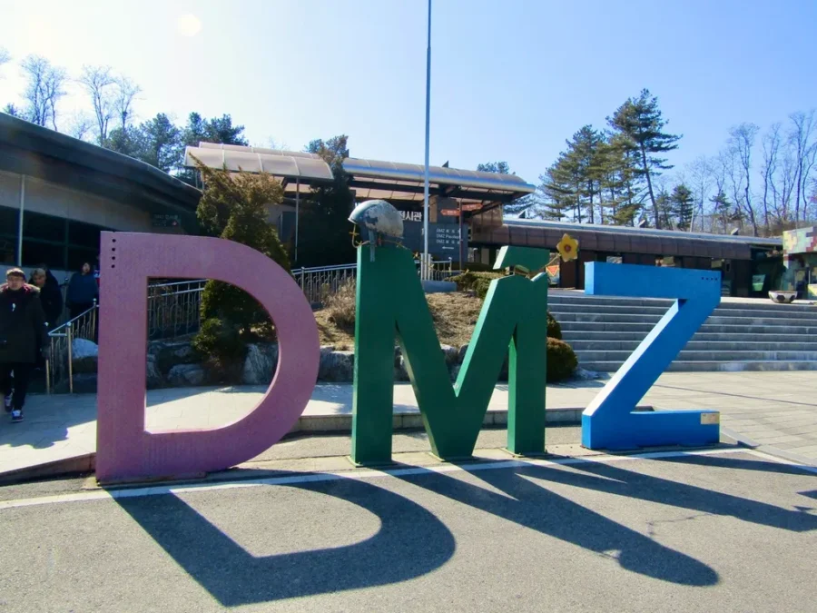Colorful DMZ letters at Koreas border, symbolizing peace amidst historical tension.