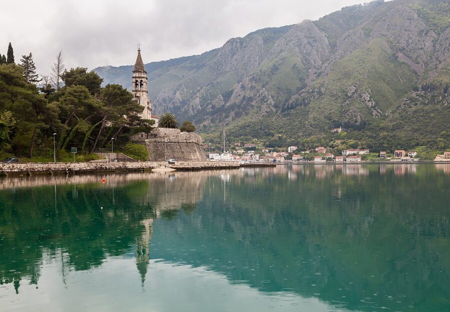 Scenic view of a church atop a hill overlooking the water in Dobrota, Kotor, Montenegro.