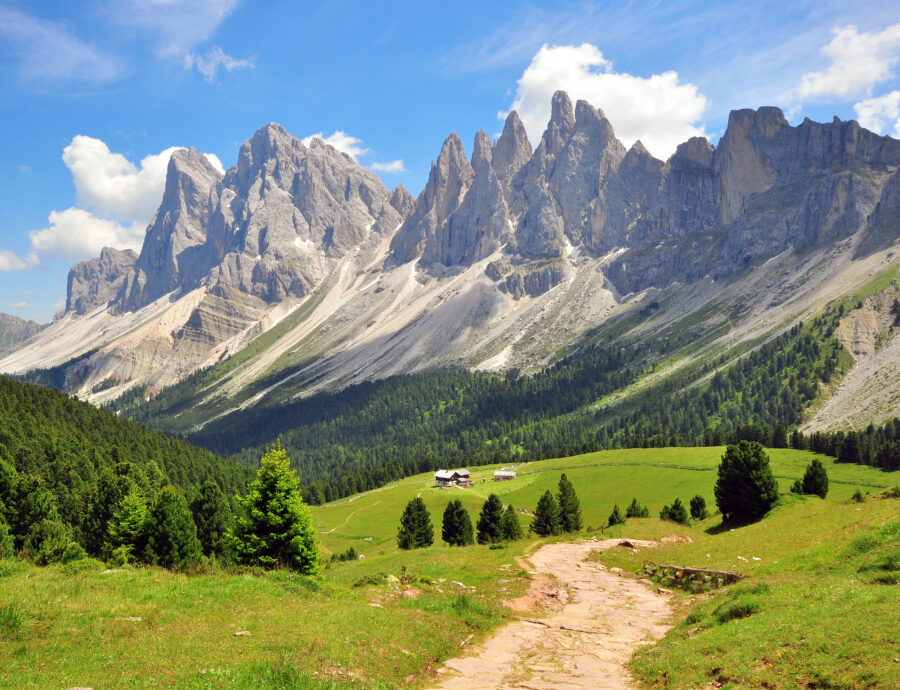 Scenic hiking path winding through the Dolomites, surrounded by towering mountains and lush greenery