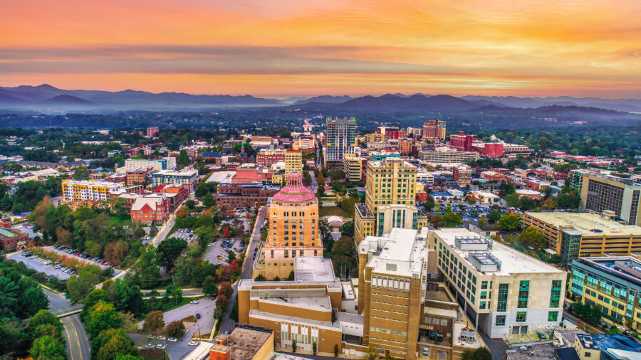 Aerial view of downtown Asheville, North Carolina, showcasing the skyline with buildings and surrounding mountains.