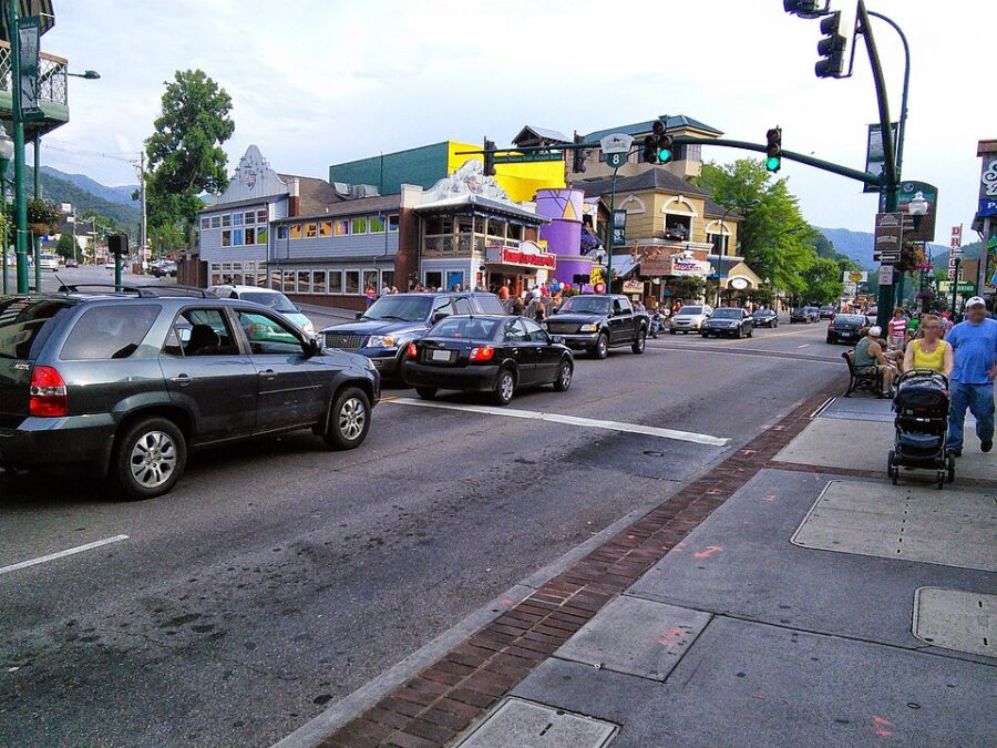 Bustling downtown Gatlinburg street filled with cars and pedestrians navigating the vibrant urban scene.