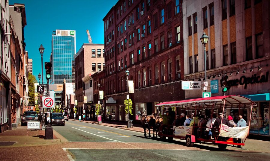 Horse-drawn carriage moves along a bustling street in downtown Halifax, Nova Scotia, Canada.