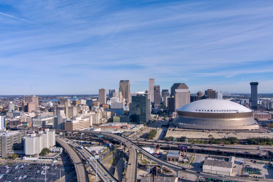 The Superdome stands prominently in downtown New Orleans, framed by city skyscrapers and lively urban activity