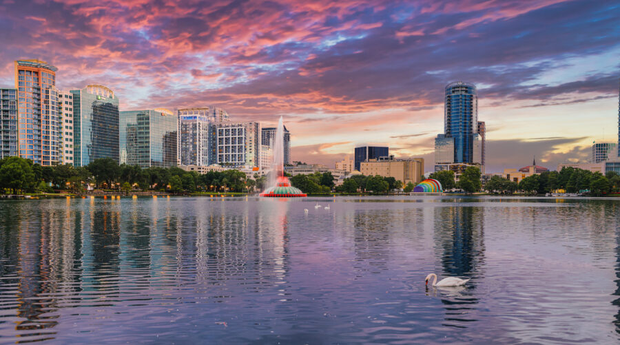 Downtown Orlando showcases sleek skyscrapers surrounded by greenery and tree-lined streets, creating a lively cityscape.
