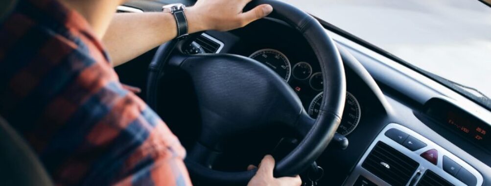 Driver grips steering wheel in modern car interior